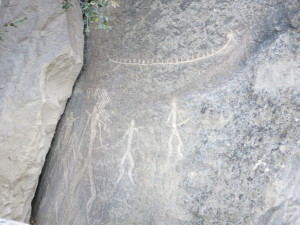 cave carving of people and ship